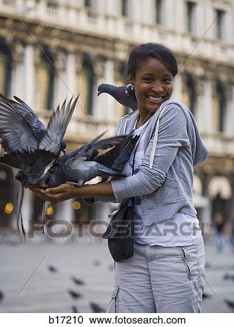 Woman in public square with pigeons smiling View Large Photo Image Stock Image - Woman in public square with pigeons smiling. Fotosearch
