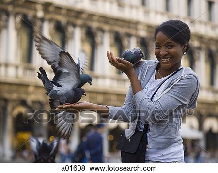 Woman in public square with pigeons smiling View Large Photo Image Stock Photo - Woman in public square with pigeons smiling. Fotosearch