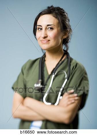 Woman in scrubs with arms crossed smiling View Large Photo Image Stock Image - Woman in scrubs with arms crossed smiling. Fotosearch