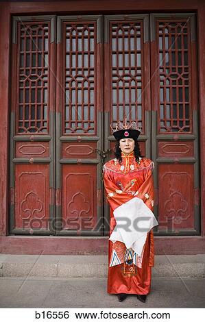 Woman in traditional Asian dress standing outside ornate doors View Large Photo Image Stock Photograph - Woman in traditional Asian dress standing outside ornate doors. Fotosearch