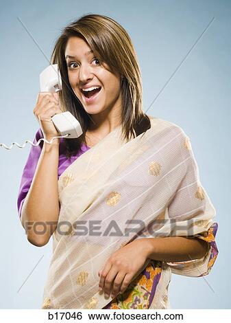 Stock Photograph - Woman in traditional East Indian dress smiling and talking on telephone. Fotosearch