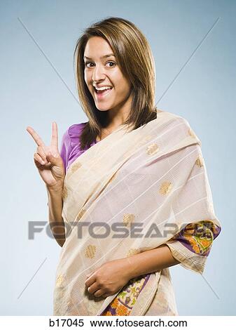 Woman in traditional East Indian dress smiling and making peace sign View Large Photo Image Stock Photography - Woman in traditional East Indian dress smiling and making peace sign. Fotosearch