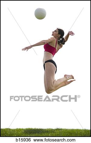 Woman jumping and spiking volleyball outdoors View Large Photo Image Stock Photograph - Woman jumping and spiking volleyball outdoors. Fotosearch
