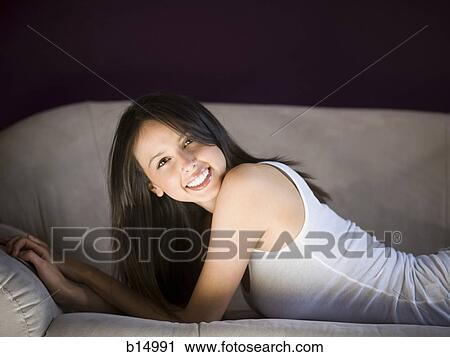 Woman laying on sofa smiling View Large Photo Image Stock Image - Woman laying on sofa smiling. Fotosearch