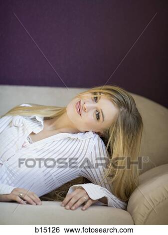 Woman laying on sofa smiling View Large Photo Image Stock Photograph - Woman laying on sofa smiling. Fotosearch