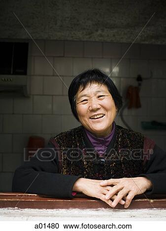 Woman leaning on windowsill smiling View Large Photo Image Stock Image - Woman leaning on windowsill smiling. Fotosearch