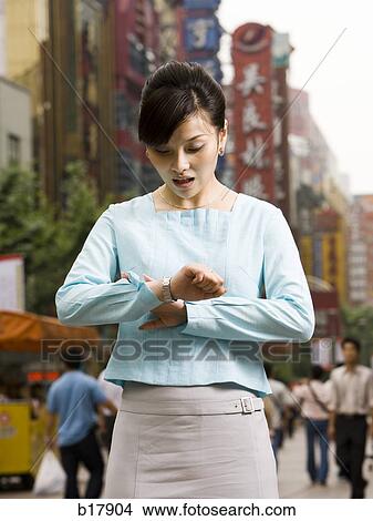 Woman looking at her watch in disbelief. View Large Photo Image Picture - Woman looking at her watch in disbelief.. Fotosearch