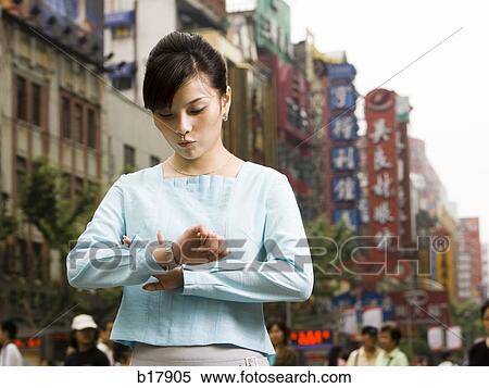 Woman looking at her watch in disbelief. View Large Photo Image Stock Photography - Woman looking at her watch in disbelief.. Fotosearch