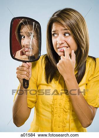 Woman looking into shattered mirror nervously View Large Photo Image Picture - Woman looking into shattered mirror nervously. Fotosearch