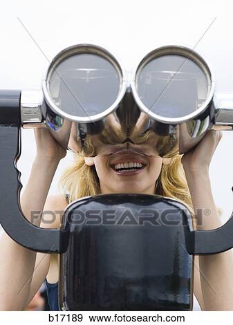 Woman looking through coin operated binoculars smiling View Large Photo Image Stock Photo - Woman looking through coin operated binoculars smiling. Fotosearch
