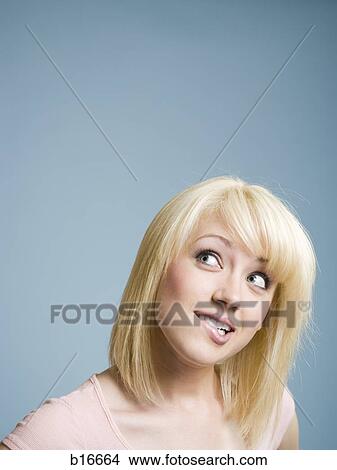 Woman looking up and biting lip View Large Photo Image Picture - Woman looking up and biting lip. Fotosearch