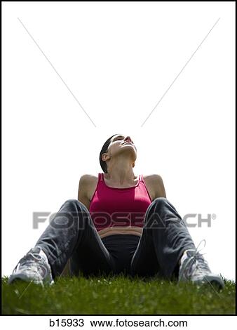 Woman lying back on grass outdoors View Large Photo Image Stock Image - Woman lying back on grass outdoors. Fotosearch