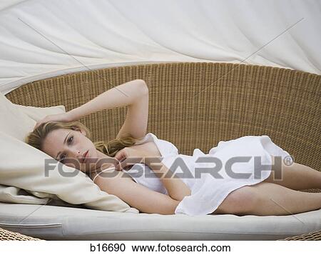 Woman lying down on lounge chair View Large Photo Image Stock Image - Woman lying down on lounge chair. Fotosearch