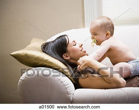 Woman lying down on sofa with baby View Large Photo Image Stock Image - Woman lying down on sofa with baby. Fotosearch