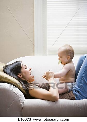 Woman lying down on sofa with baby View Large Photo Image Stock Image - Woman lying down on sofa with baby. Fotosearch