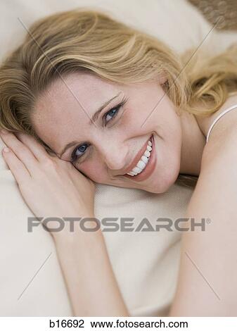 Woman lying down smiling View Large Photo Image Stock Image - Woman lying down smiling. Fotosearch