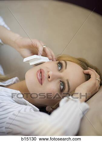 Woman lying on sofa talking on cell phone View Large Photo Image Stock Image - Woman lying on sofa talking on cell phone. Fotosearch
