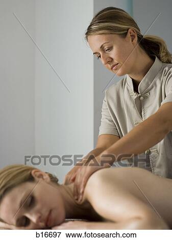 Woman massaging female View Large Photo Image Stock Photo - Woman massaging female. Fotosearch