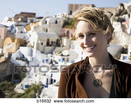 Woman outdoors smiling with village and water in background View Large Photo Image Stock Image - Woman outdoors smiling with village and water in background. Fotosearch
