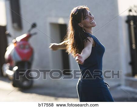 Woman outdoors with arms out smiling View Large Photo Image Stock Photo - Woman outdoors with arms out smiling. Fotosearch
