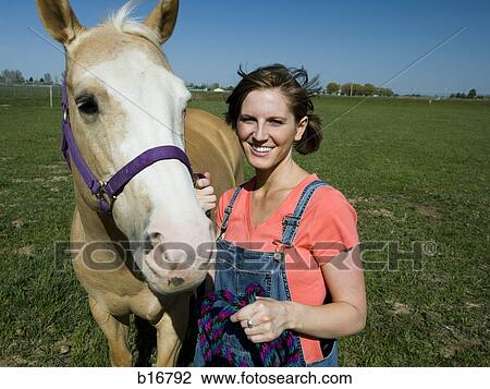 Stock Image - Woman outdoors with horse smiling. Fotosearch