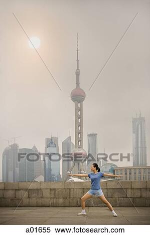 Woman practicing Tai Chi in front of cityscape. View Large Photo Image Stock Photography - Woman practicing Tai Chi in front of cityscape.. Fotosearch