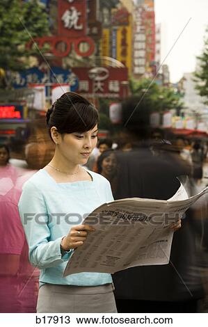 Stock Image - Woman reading a newspaper.. Fotosearch