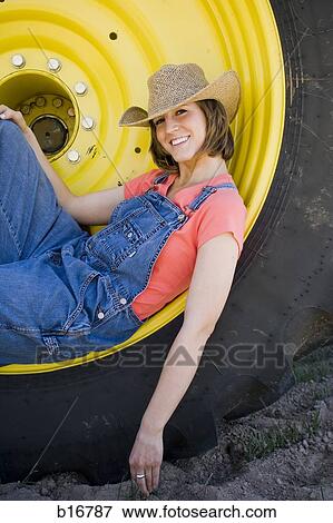 Woman reclining in tire with straw hat smiling View Large Photo Image Stock Photo - Woman reclining in tire with straw hat smiling. Fotosearch
