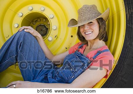 Woman reclining in tire with straw hat smiling View Large Photo Image Stock Photograph - Woman reclining in tire with straw hat smiling. Fotosearch