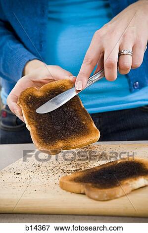 woman scraping burnt toast View Large Photo Image Stock Photo - woman scraping burnt toast. Fotosearch