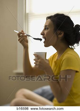Woman sitting and eating ice cream View Large Photo Image Stock Photo - Woman sitting and eating ice cream. Fotosearch