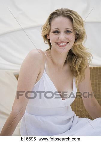 Stock Photography - Woman sitting and smiling. Fotosearch