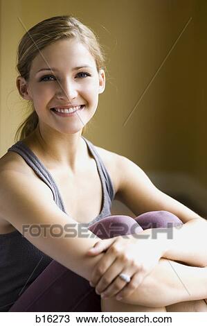 Woman sitting and smiling with arms around knees View Large Photo Image Stock Image - Woman sitting and smiling with arms around knees. Fotosearch