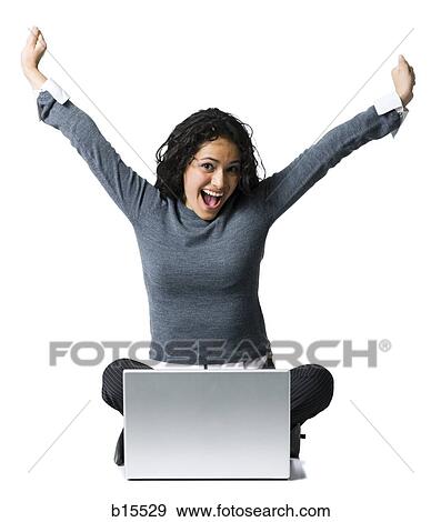 Woman sitting cross legged with laptop and arms up View Large Photo Image Stock Photo - Woman sitting cross legged with laptop and arms up. Fotosearch