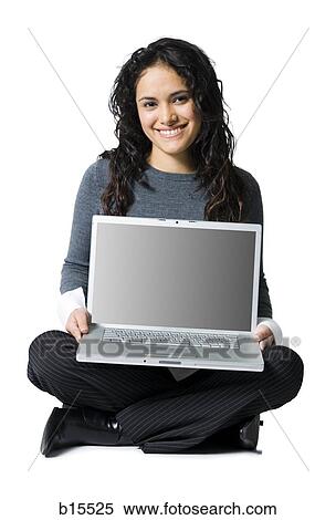 Stock Photography - Woman sitting cross legged with laptop smiling. Fotosearch