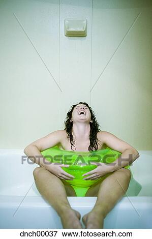 Woman sitting in bathtub with inflatable ring screaming View Large Photo Image Stock Photo - Woman sitting in bathtub with inflatable ring screaming. Fotosearch
