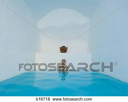 Woman sitting in pool with knees up under clay urn View Large Photo Image Stock Photo - Woman sitting in pool with knees up under clay urn. Fotosearch