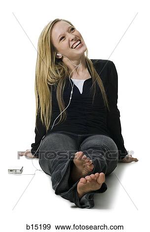 Woman sitting listening to mp3 player View Large Photo Image Stock Photo - Woman sitting listening to mp3 player. Fotosearch