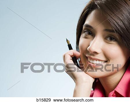 Woman sitting with fountain pen smiling View Large Photo Image Stock Photo - Woman sitting with fountain pen smiling. Fotosearch