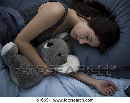 Woman sleeping in bed with stuffed animal View Large Photo Image Stock Image - Woman sleeping in bed with stuffed animal. Fotosearch