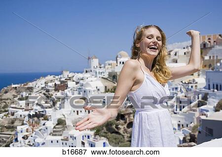 Woman smiling with arms up and village in background View Large Photo Image Stock Photo - Woman smiling with arms up and village in background. Fotosearch