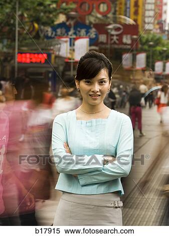 Stock Photography - Woman standing on a busy city street.. Fotosearch