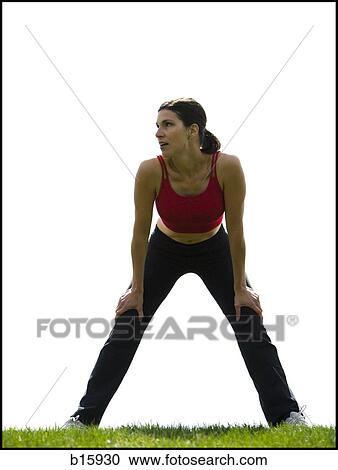 Woman standing on grass outdoors stretching View Large Photo Image Stock Image - Woman standing on grass outdoors stretching. Fotosearch