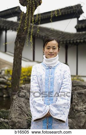 Woman standing outdoors with rock formation and building smiling View Large Photo Image Stock Photography - Woman standing outdoors with rock formation and building smiling. Fotosearch