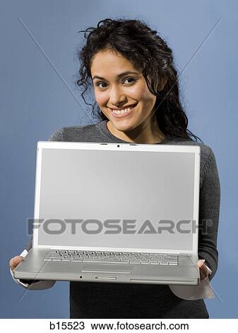 Woman standing with blank laptop smiling View Large Photo Image Stock Image - Woman standing with blank laptop smiling. Fotosearch