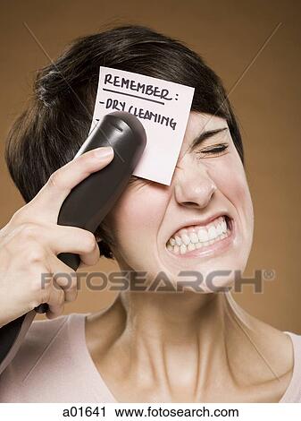 Woman stapling list of things to remember to her forehead and wincing View Large Photo Image Stock Image - Woman stapling list of things to remember to her forehead and wincing. Fotosearch