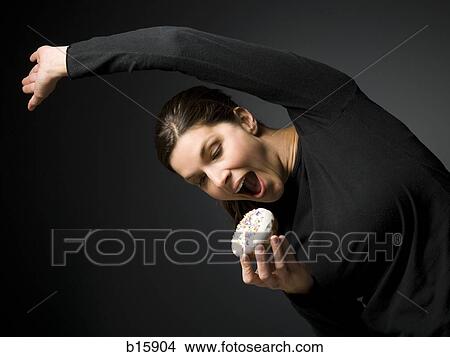Woman stretching and about to eat donut View Large Photo Image Picture - Woman stretching and about to eat donut. Fotosearch