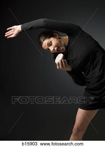 Woman stretching and holding donut View Large Photo Image Stock Image - Woman stretching and holding donut. Fotosearch