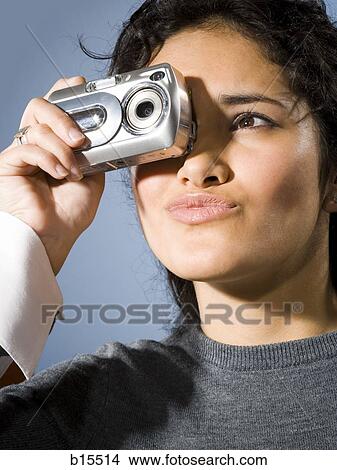 Woman taking a photo with digital camera smiling View Large Photo Image Picture - Woman taking a photo with digital camera smiling. Fotosearch