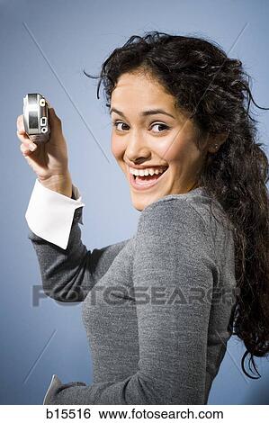 Woman taking a photo with digital camera smiling View Large Photo Image Stock Photograph - Woman taking a photo with digital camera smiling. Fotosearch
